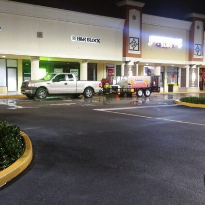 pressure washing car parked on road